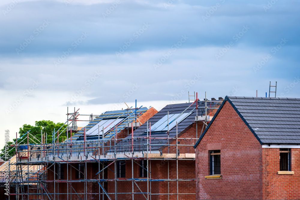 Une rangée de maisons en construction avec des échafaudages autour d'elles.