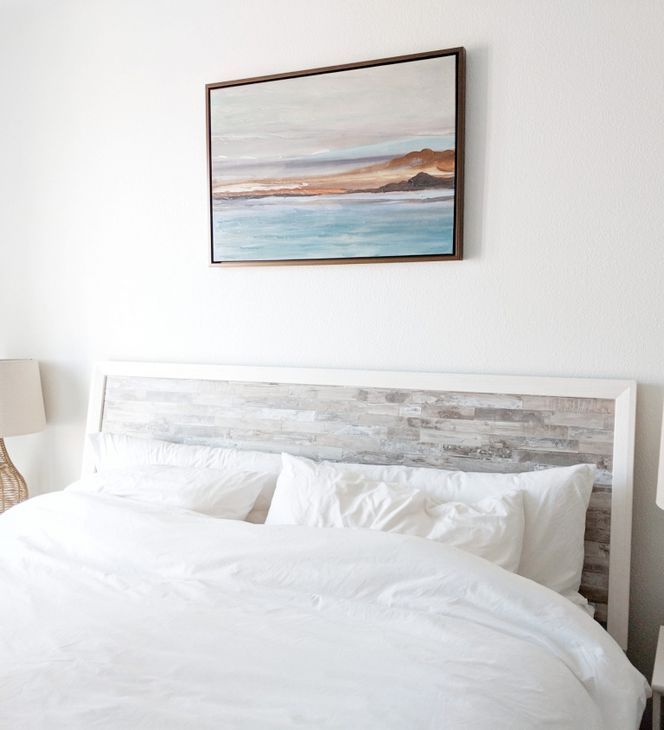 Un dormitorio con una cama y un cuadro en la pared encima.