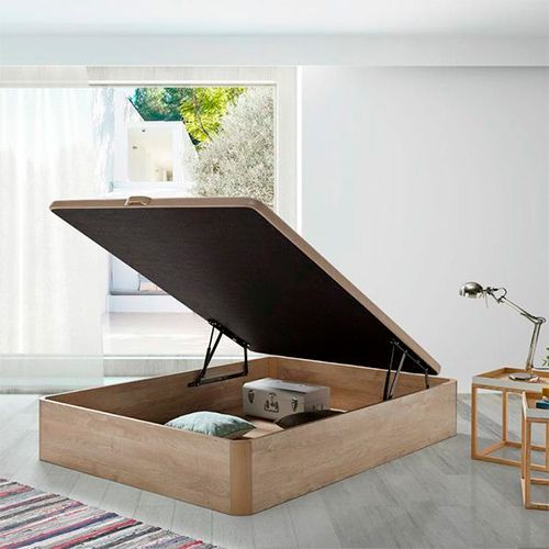 Una cama con un colchón y un cabecero en un dormitorio.