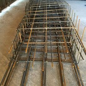Estructura de barras de refuerzo metálicas para una estructura de hormigón dispuesta en el suelo de un taller.