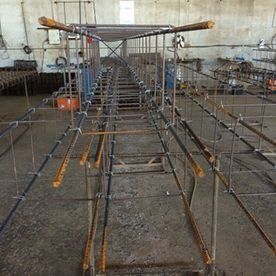 Estructura de barras de refuerzo para una cimentación de hormigón dentro de una obra en construcción sin terminar.