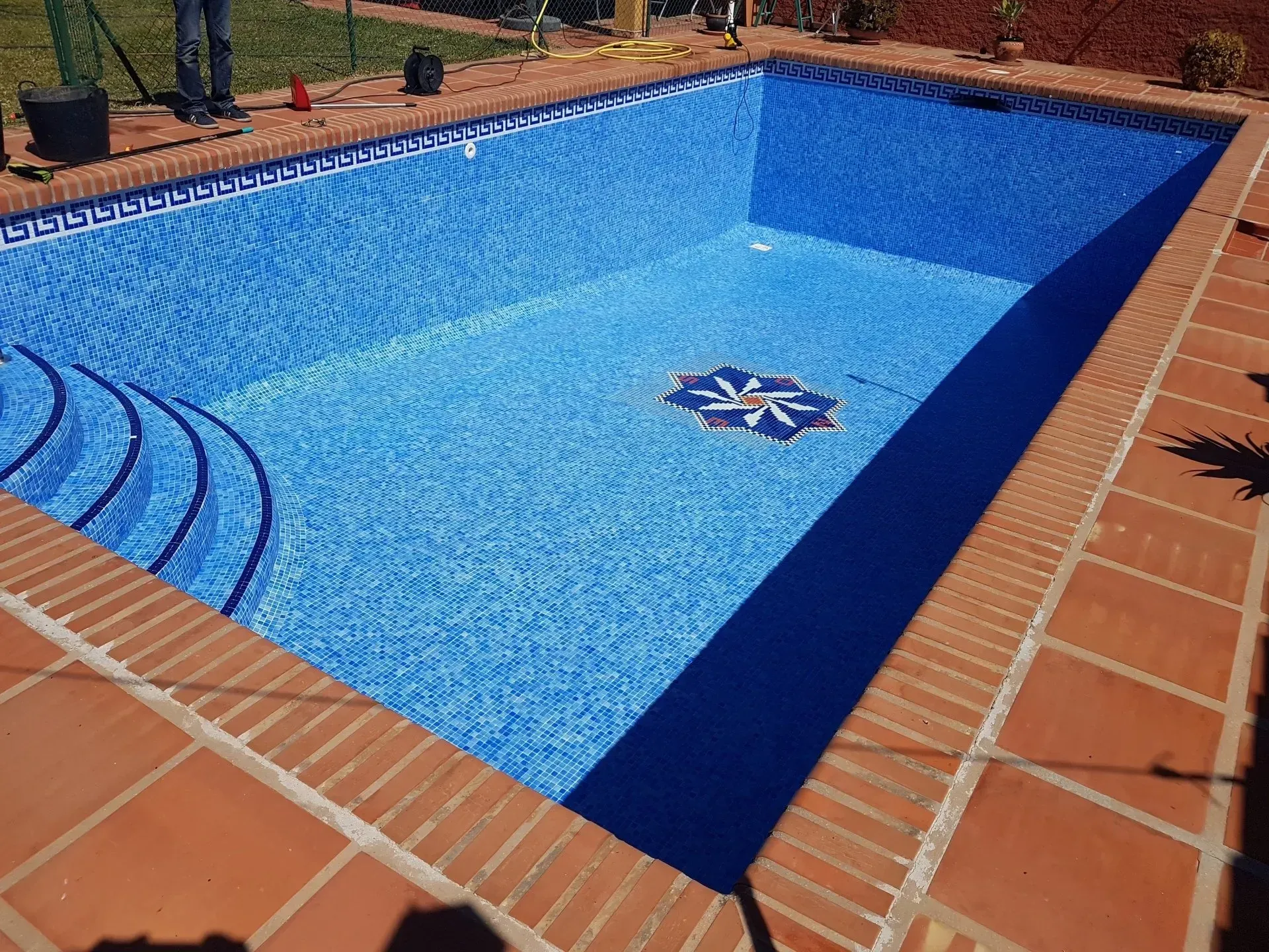 Una piscina con azulejos azules y un borde azul