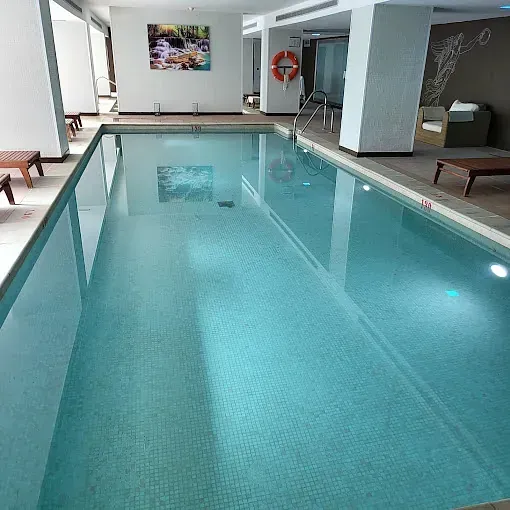 Una gran piscina cubierta con un salvavidas al costado.