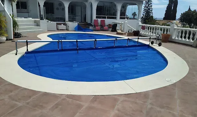 Una gran piscina con una cubierta azul.