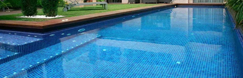 Hay una gran piscina en el patio trasero de una casa.