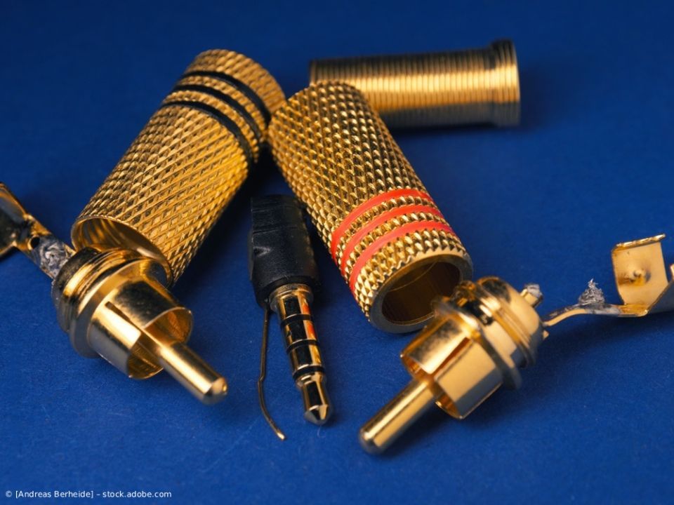 Drei goldene RCA-Audioanschlüsse und ein 3,5-mm-Klinkenstecker auf blauem Hintergrund