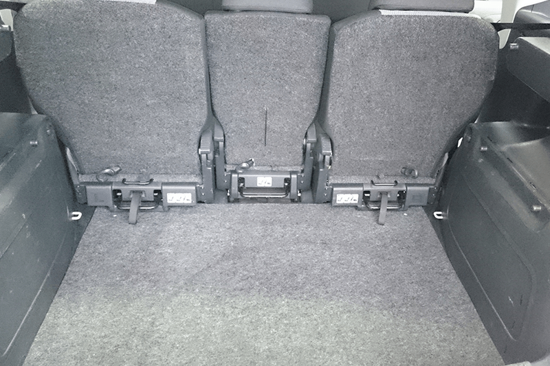 Die Rücksitze wurden umgeklappt und gaben den Laderaum frei. Grauer Teppich, schwarze Sitze und umlaufende Kunststoffteile.