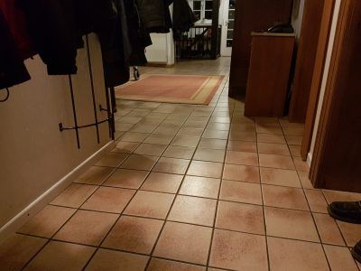 Fliesenarbeiten eines Bauernhause - Flur mit alten braunen Fliesen.