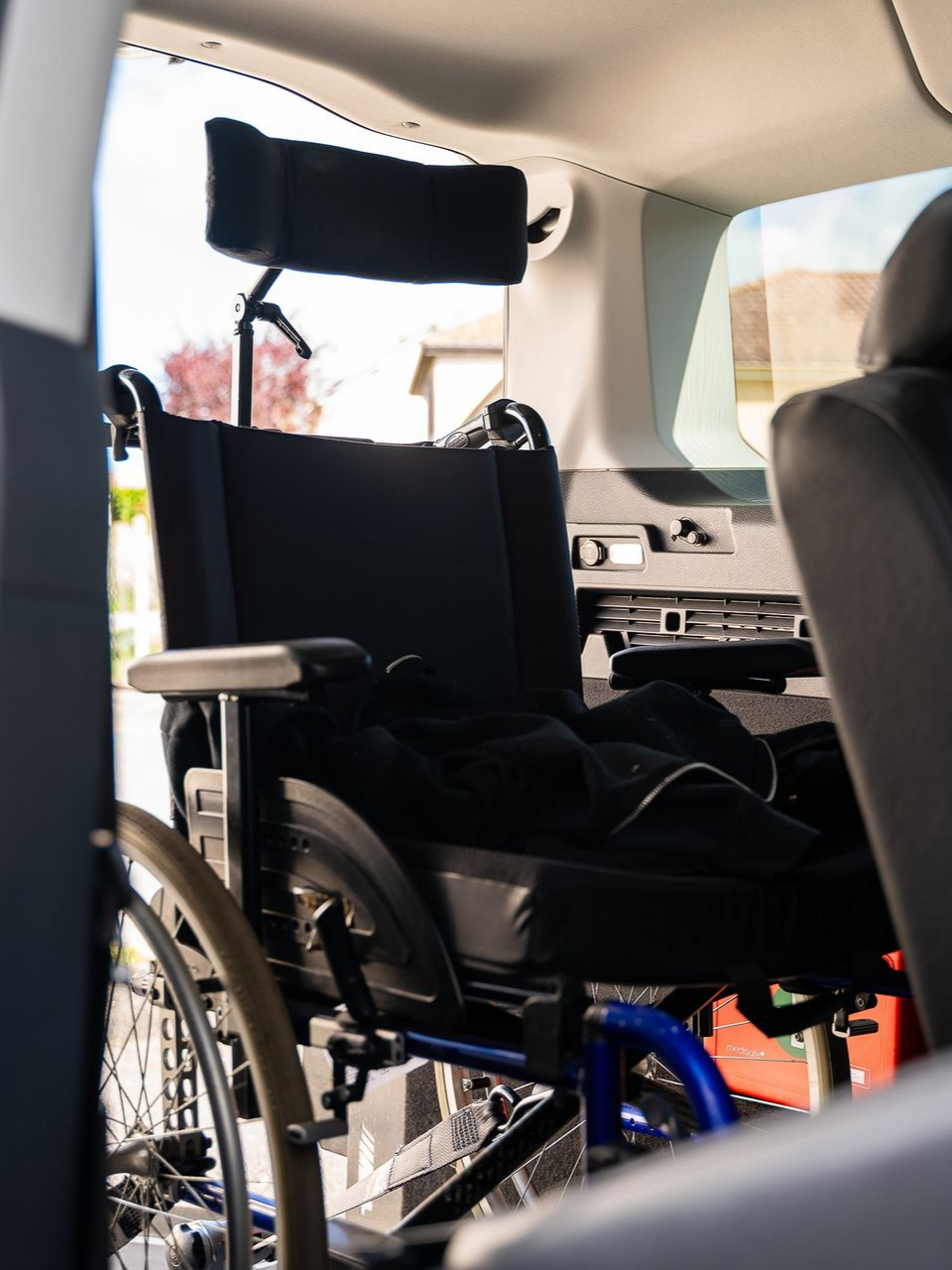 Fauteuil roulant sécurisé à l'intérieur du véhicule adapté.