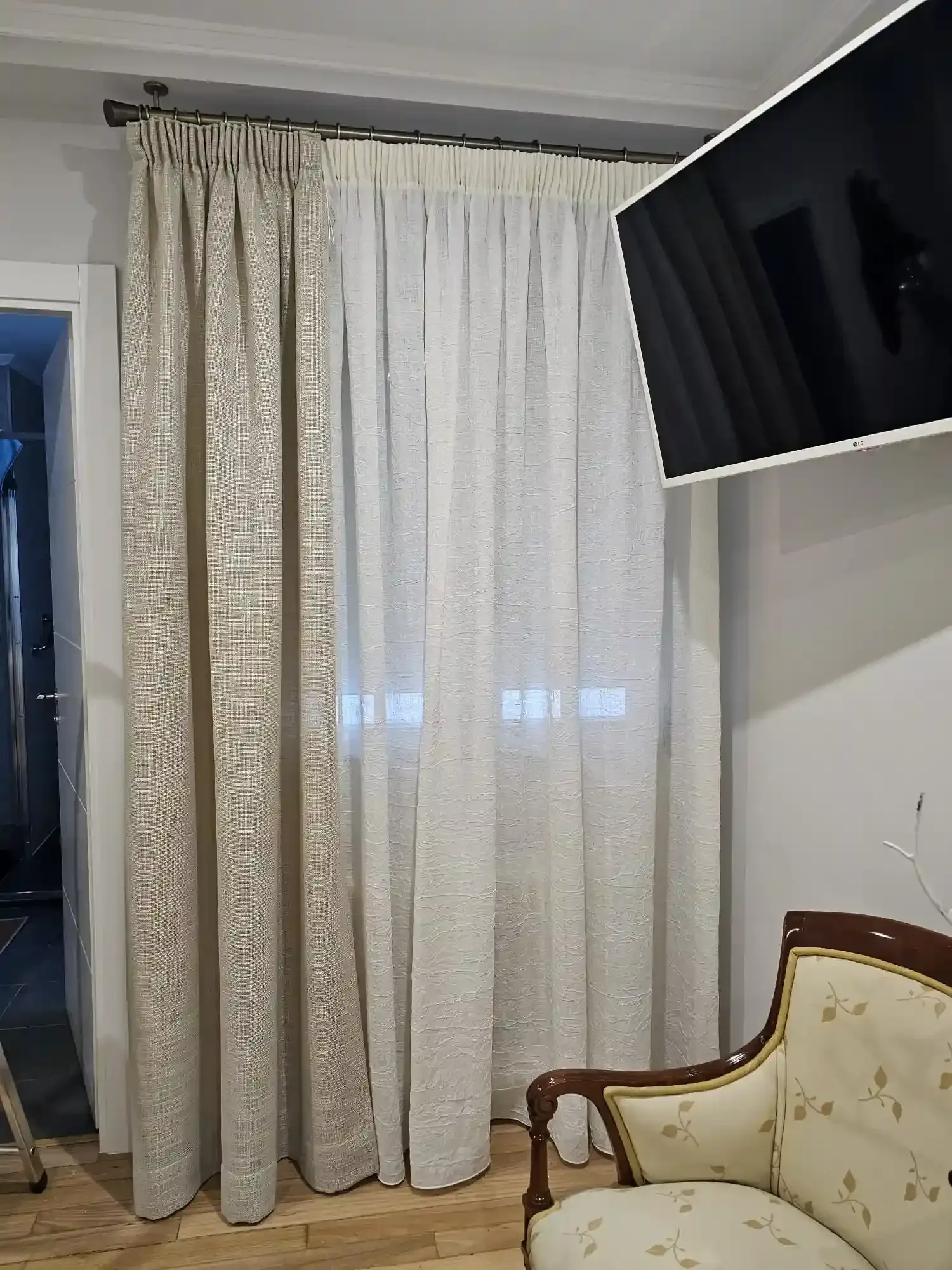 Rincón de la sala de estar con cortinas estampadas de color beige