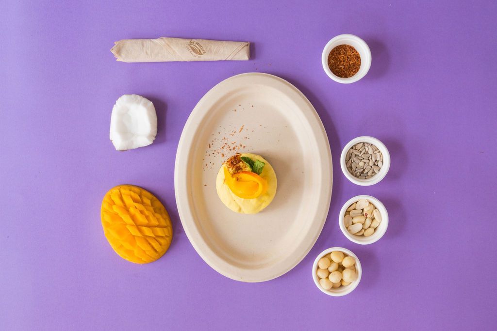 Un plato de comida está rodeado de cuencos de comida sobre una mesa morada.