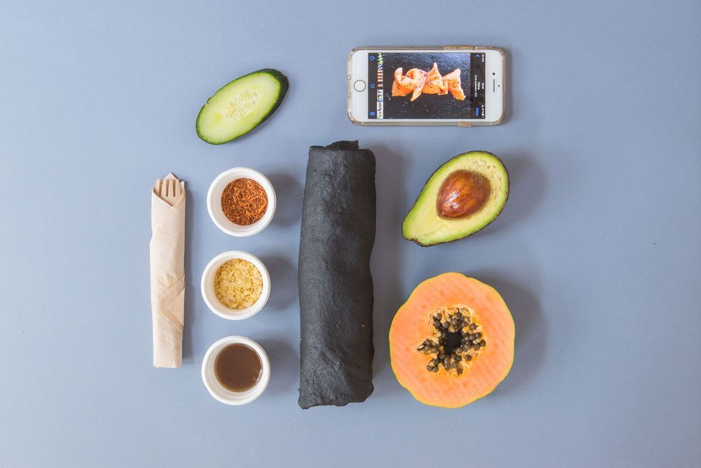 Un montón de comida y un teléfono celular sobre una mesa.