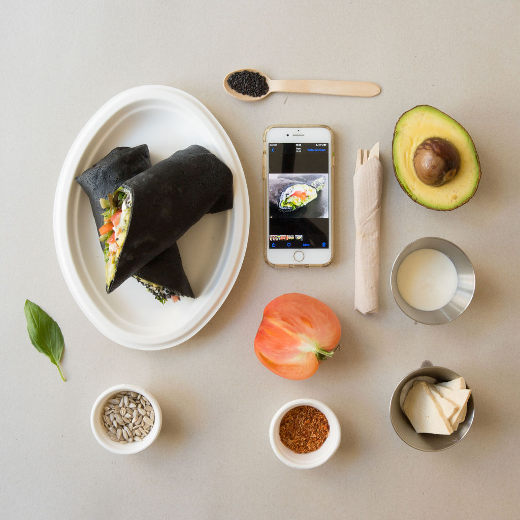 Una tortilla está en un plato al lado de un teléfono celular.