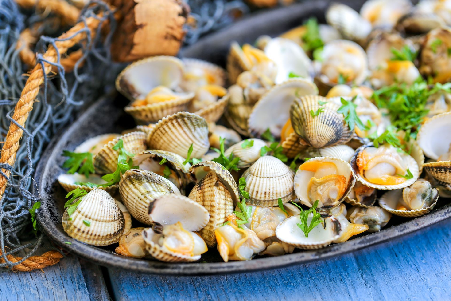 Palourdes ouvertes aux herbes sur un plat de service foncé