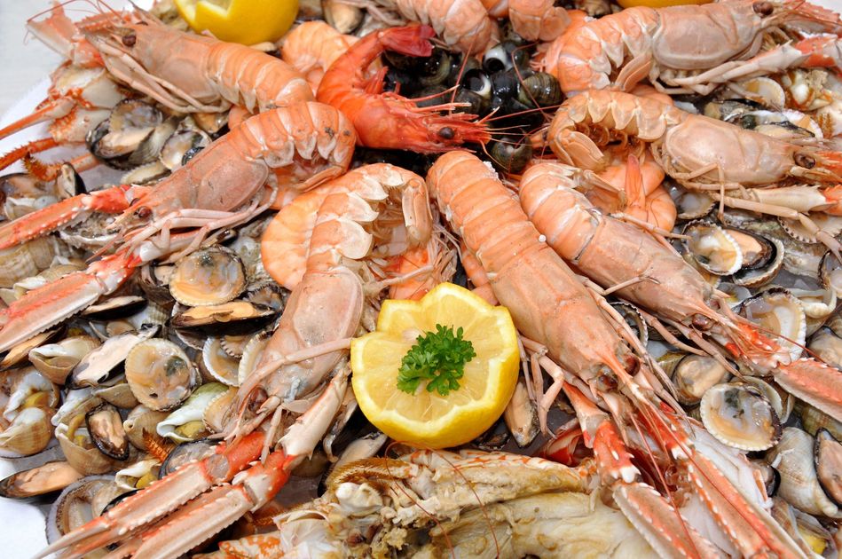 Plateau de fruits de mer avec crevettes, moules et garniture de citron sur glace, disposé en cercle
