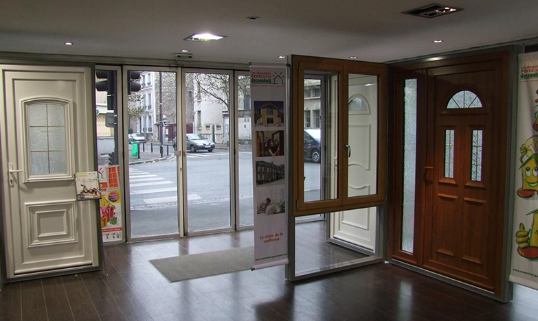 Salle d'exposition présentant plusieurs styles de portes d'entrée, avec vue sur une rue à l'extérieur.