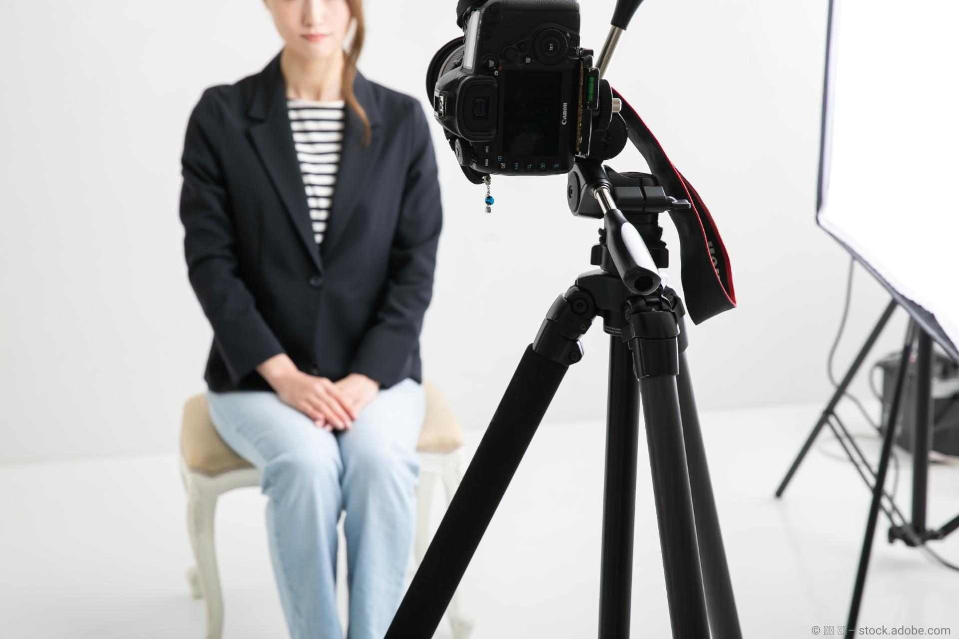 Eine Frau sitzt auf einem Stuhl vor der Kamera