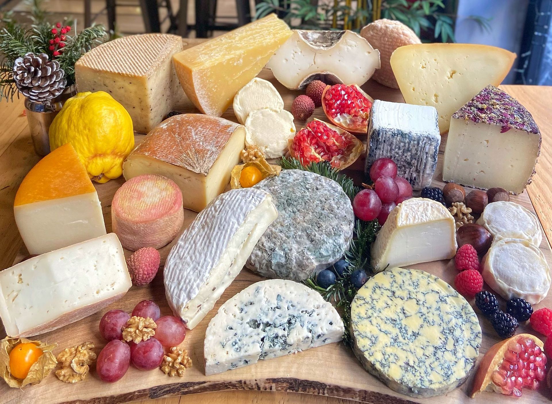 Estanterías con ruedas de queso curado, de distintos tamaños y color dorado, en un almacén de madera.