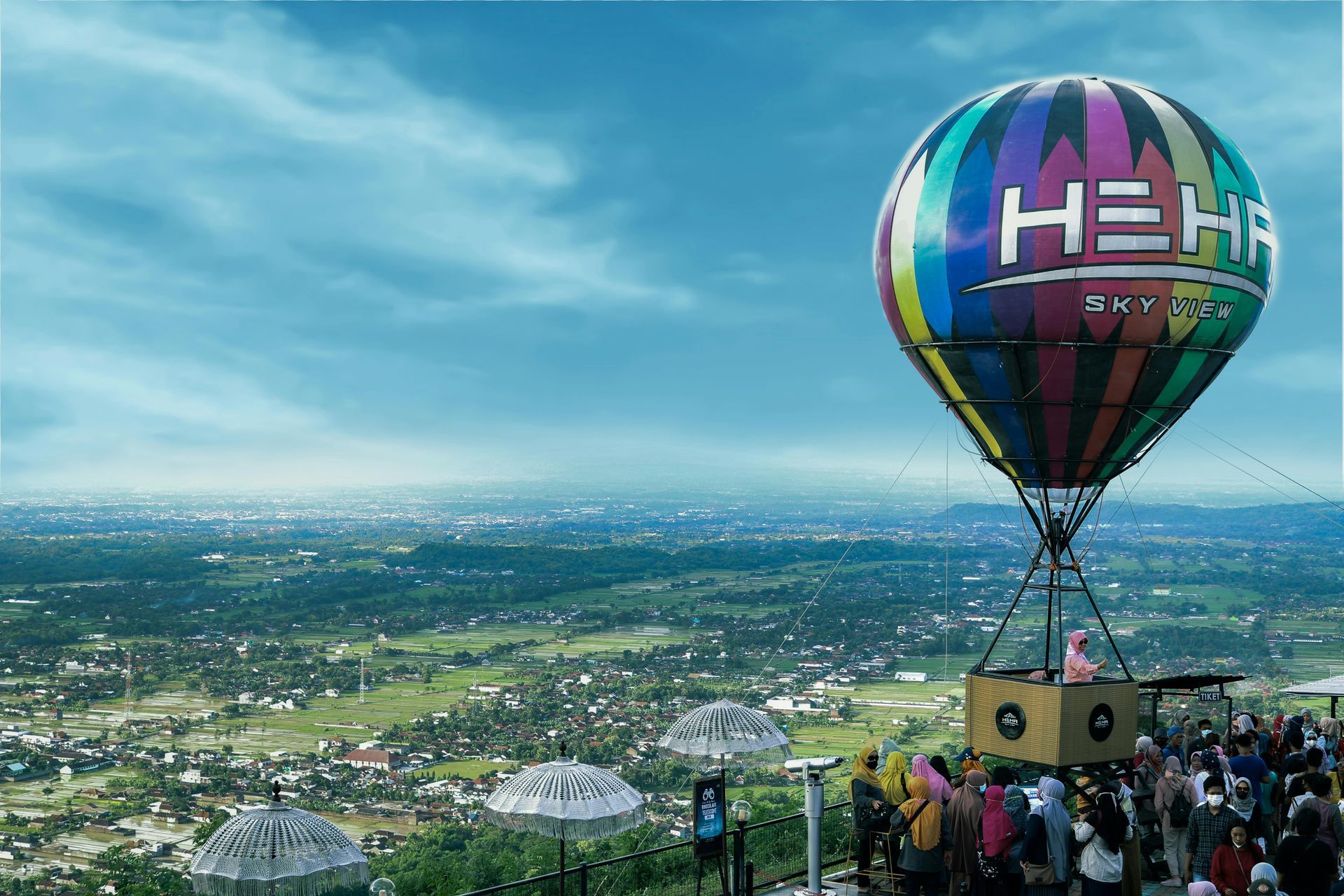 A colorful hot air balloon is flying over a city.