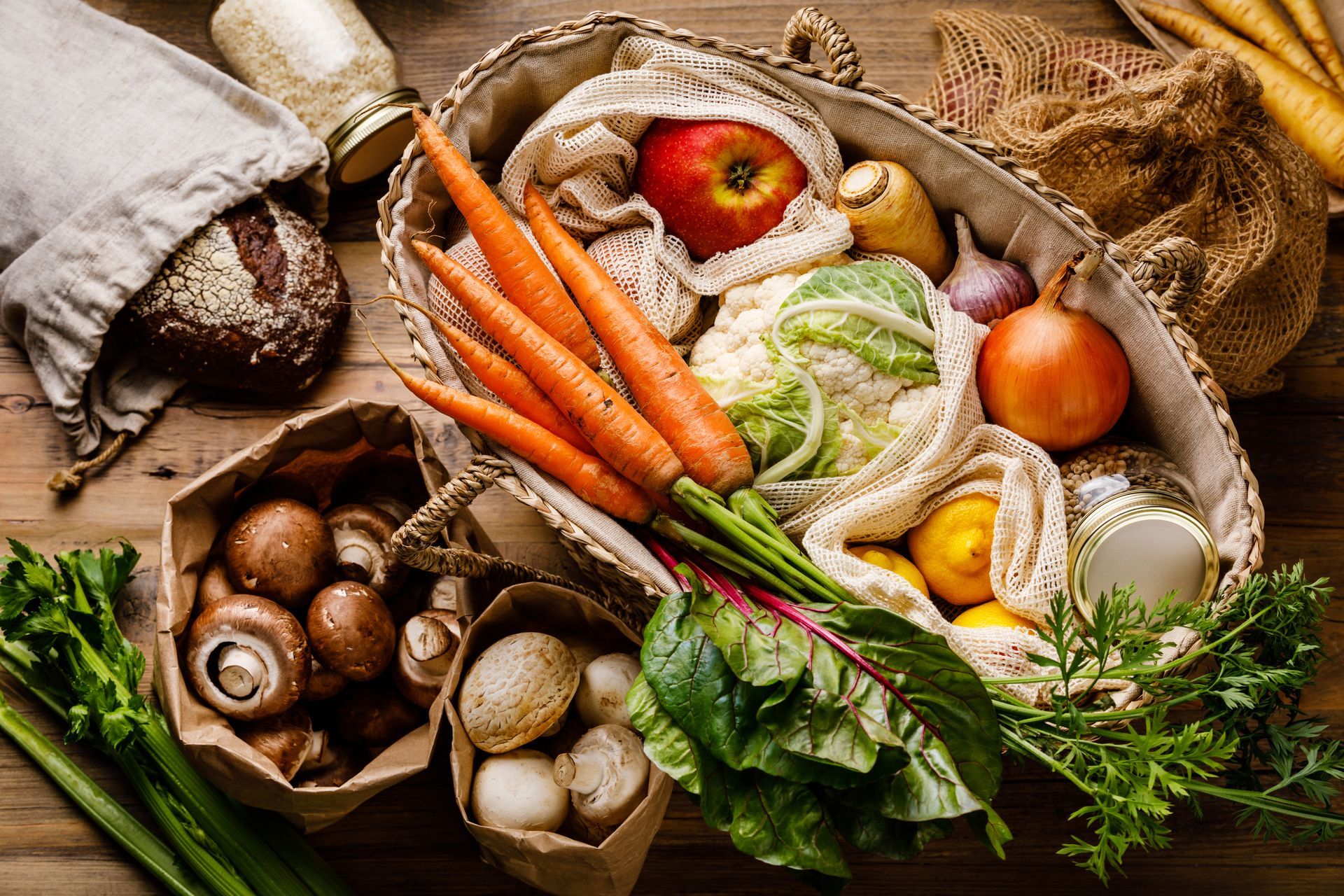 Légumes frais et champignons variés dans des paniers rustiques sur une table.