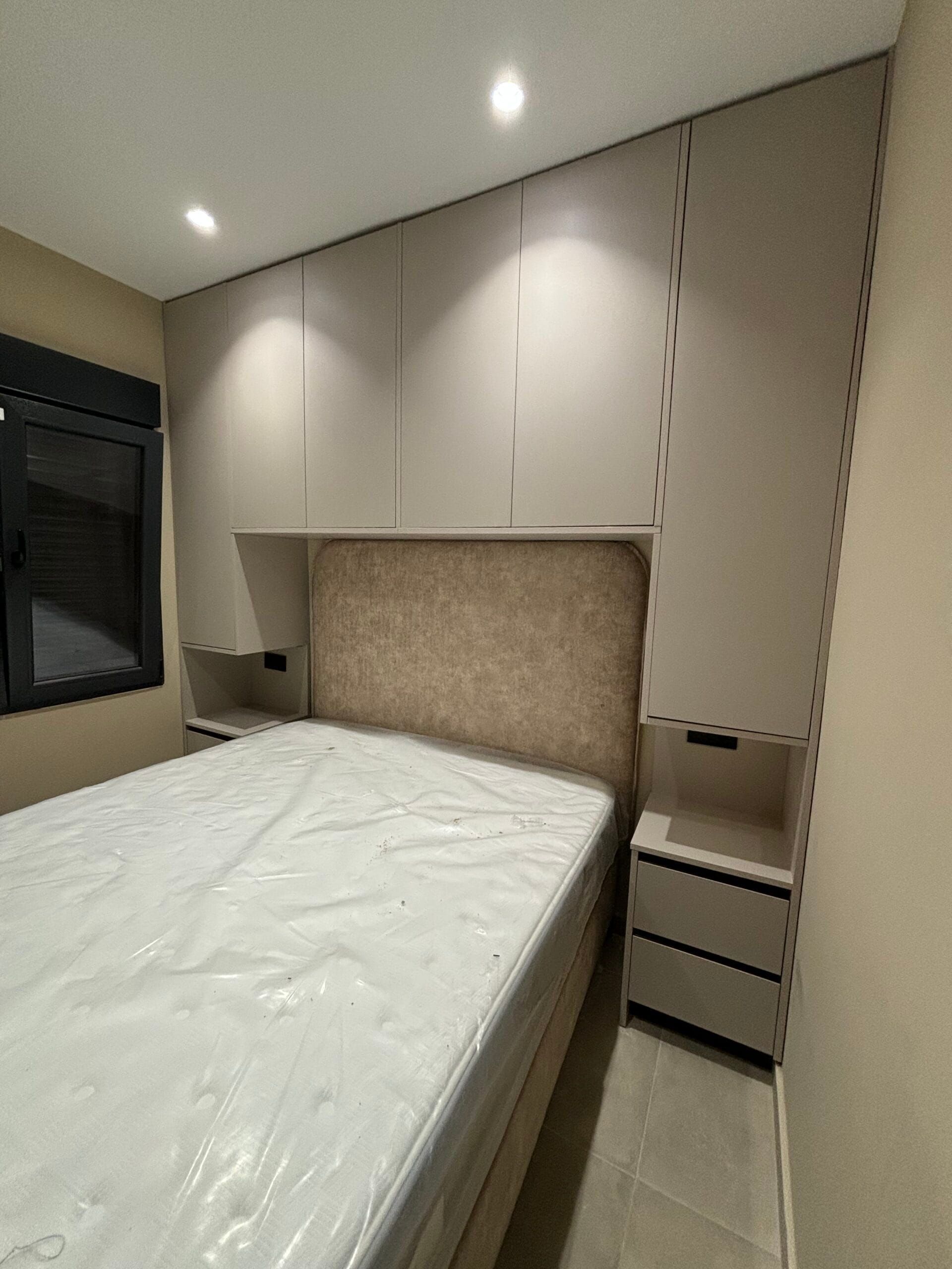 Dormitorio con cama, cabecero, armario empotrado y dos mesitas de noche.