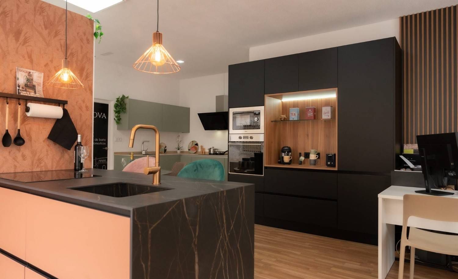 Cocina moderna con gabinetes negros y coral, detalles de cobre y piso de madera.