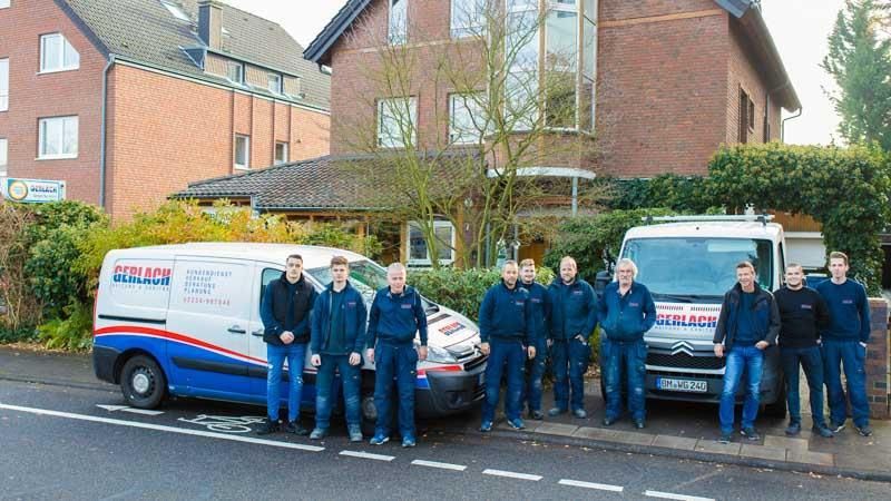 Eine Gruppe von Männern posiert für ein Foto vor ihren Lieferwagen