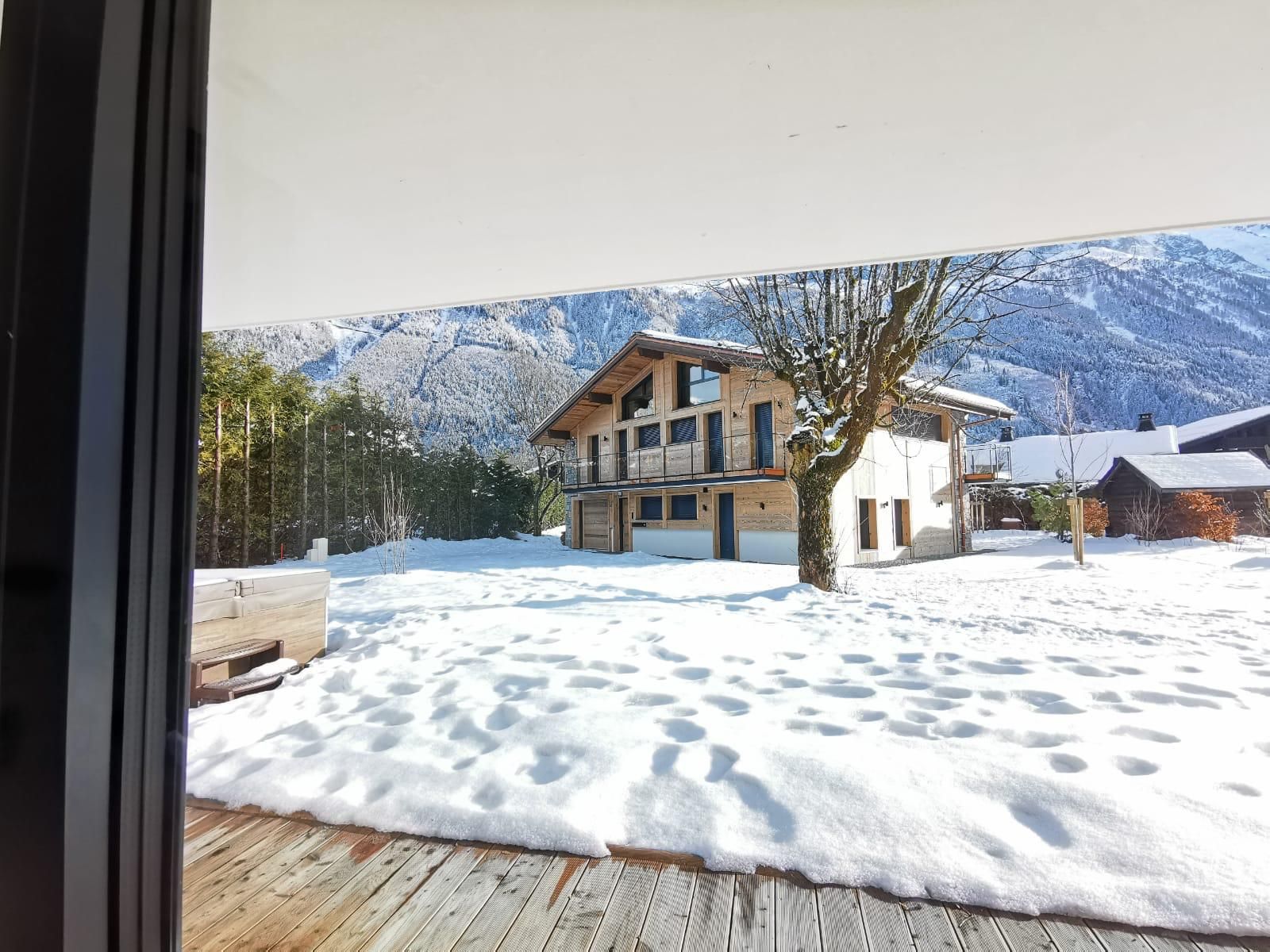 Une maison avec un jardin recouvert de neige