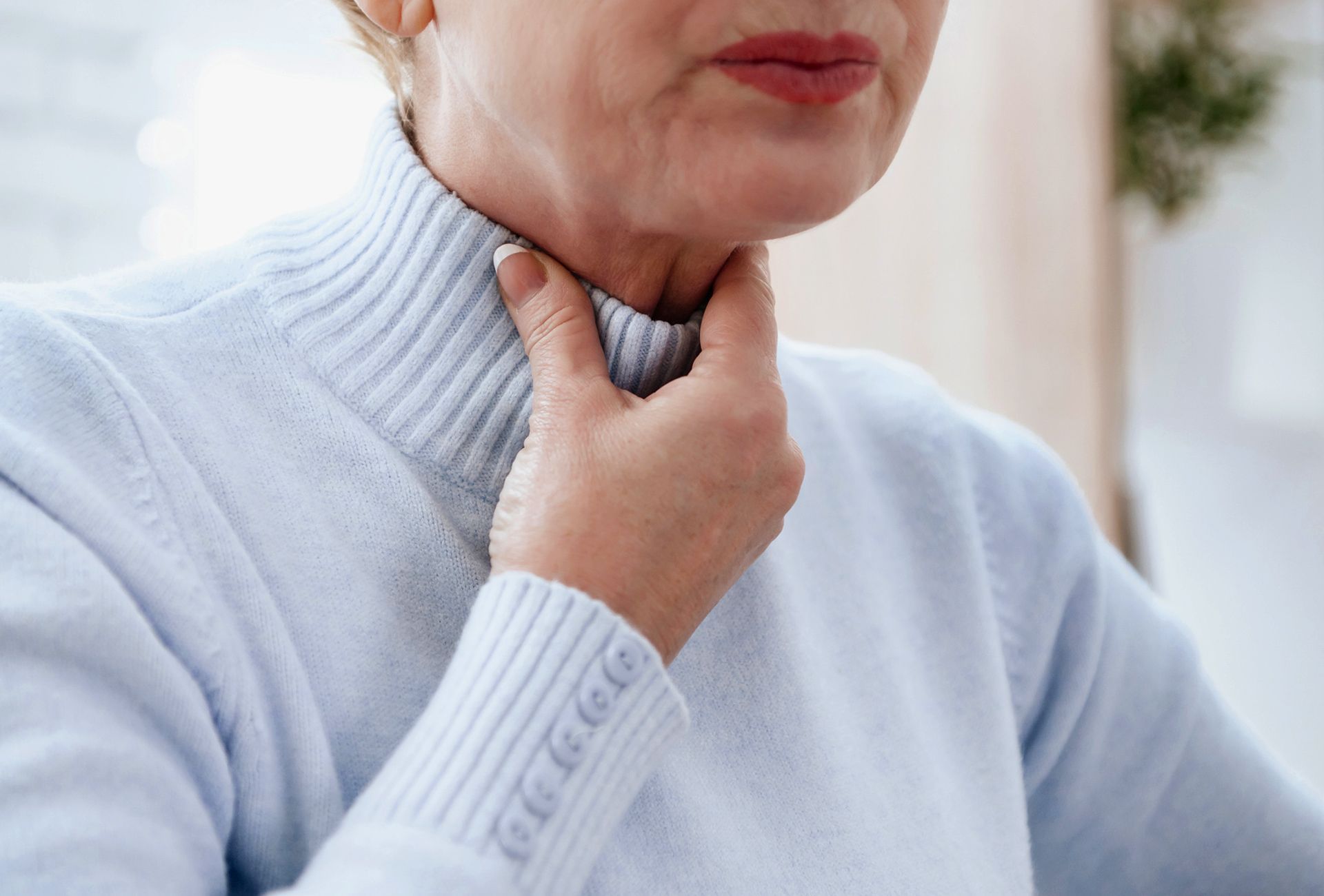 Uma mulher está tendo seu nariz examinado por um médico.