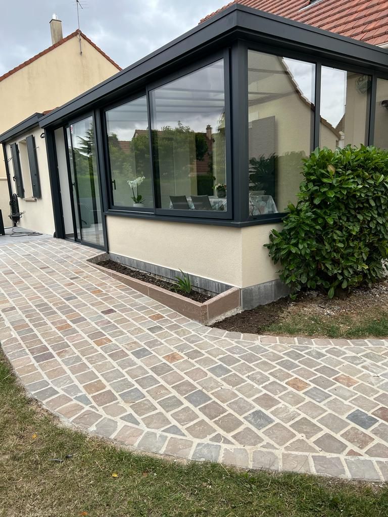 Une véranda avec une allée pavée