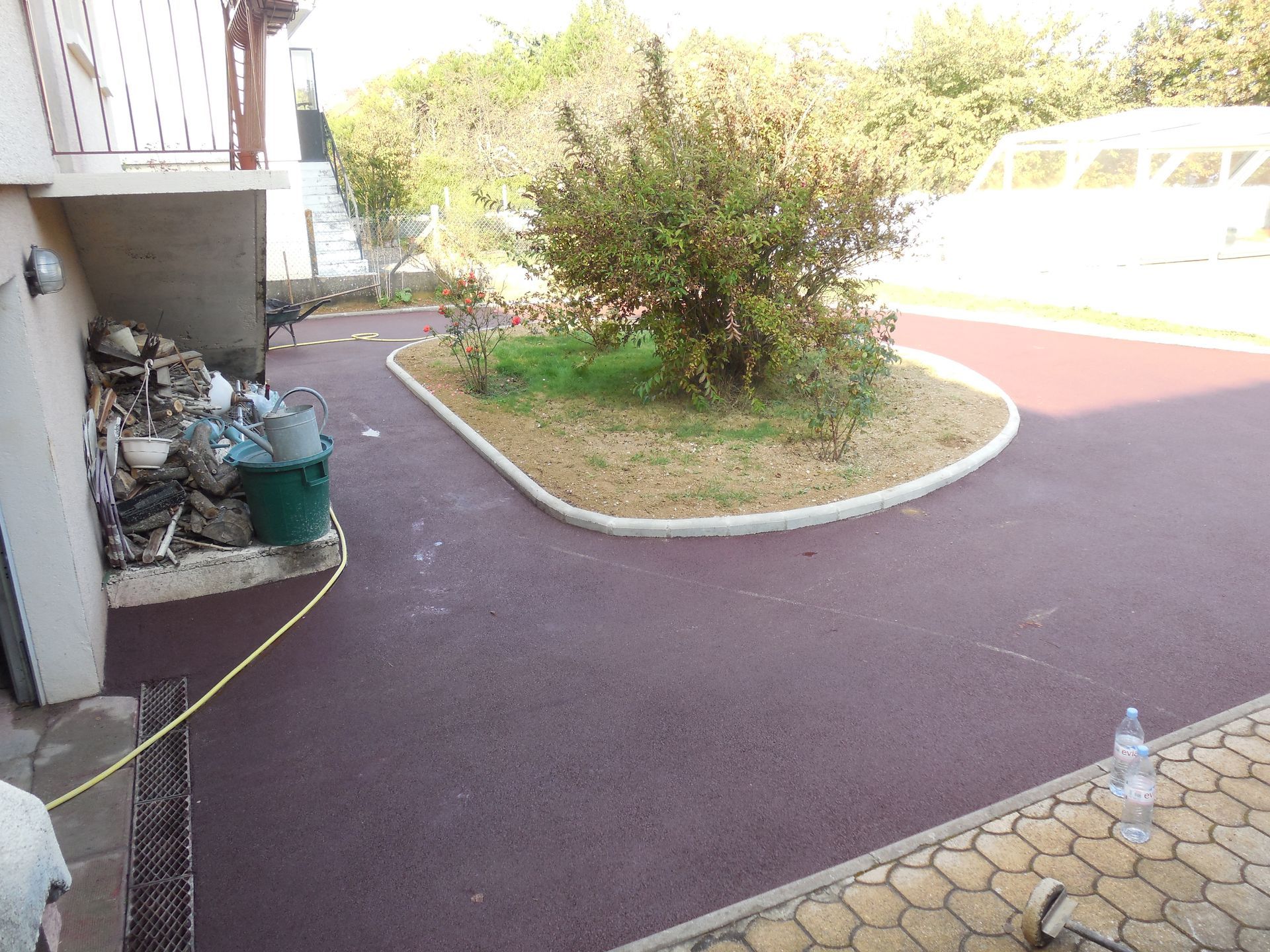 Un autre angle de vue d'une allée d'un maison goudronné de couleur bordeaux