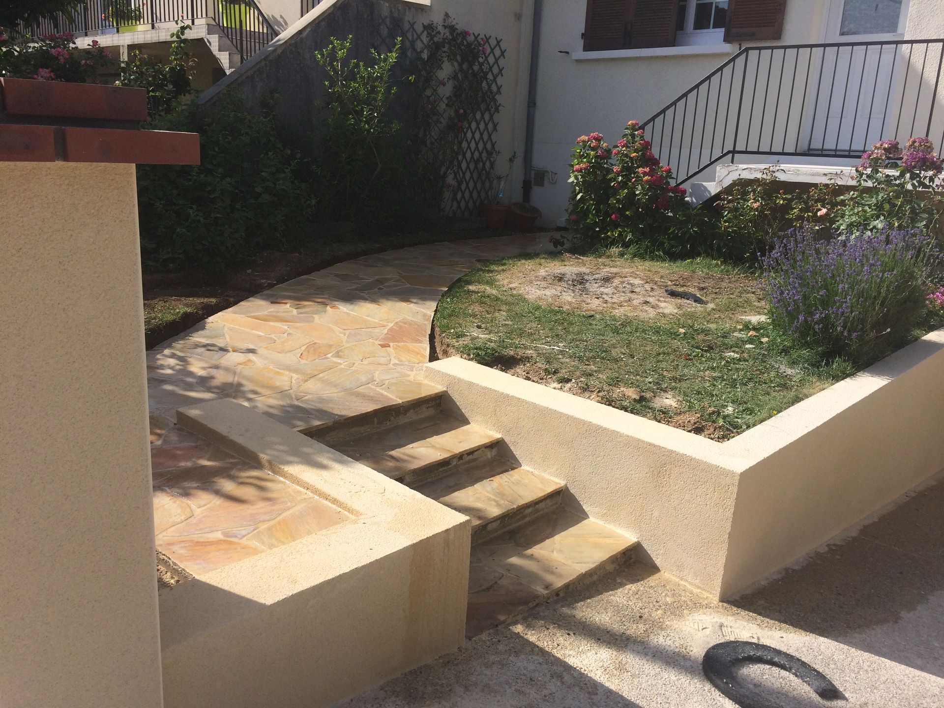 Allée de jardin avec un escalier et un terrain vert