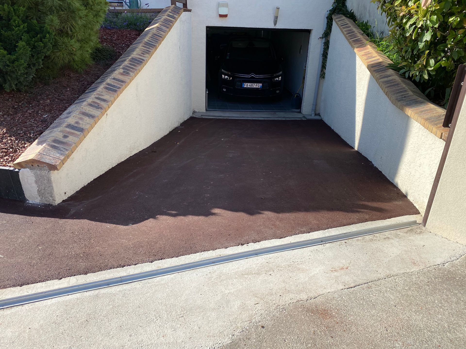 Sol extérieur goudronné donnant accès au garage  