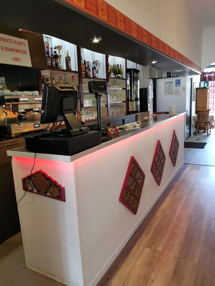 Comptoir de café moderne avec façade blanche, éclairage d'ambiance rouge et machines à expresso dans un intérieur lumineux