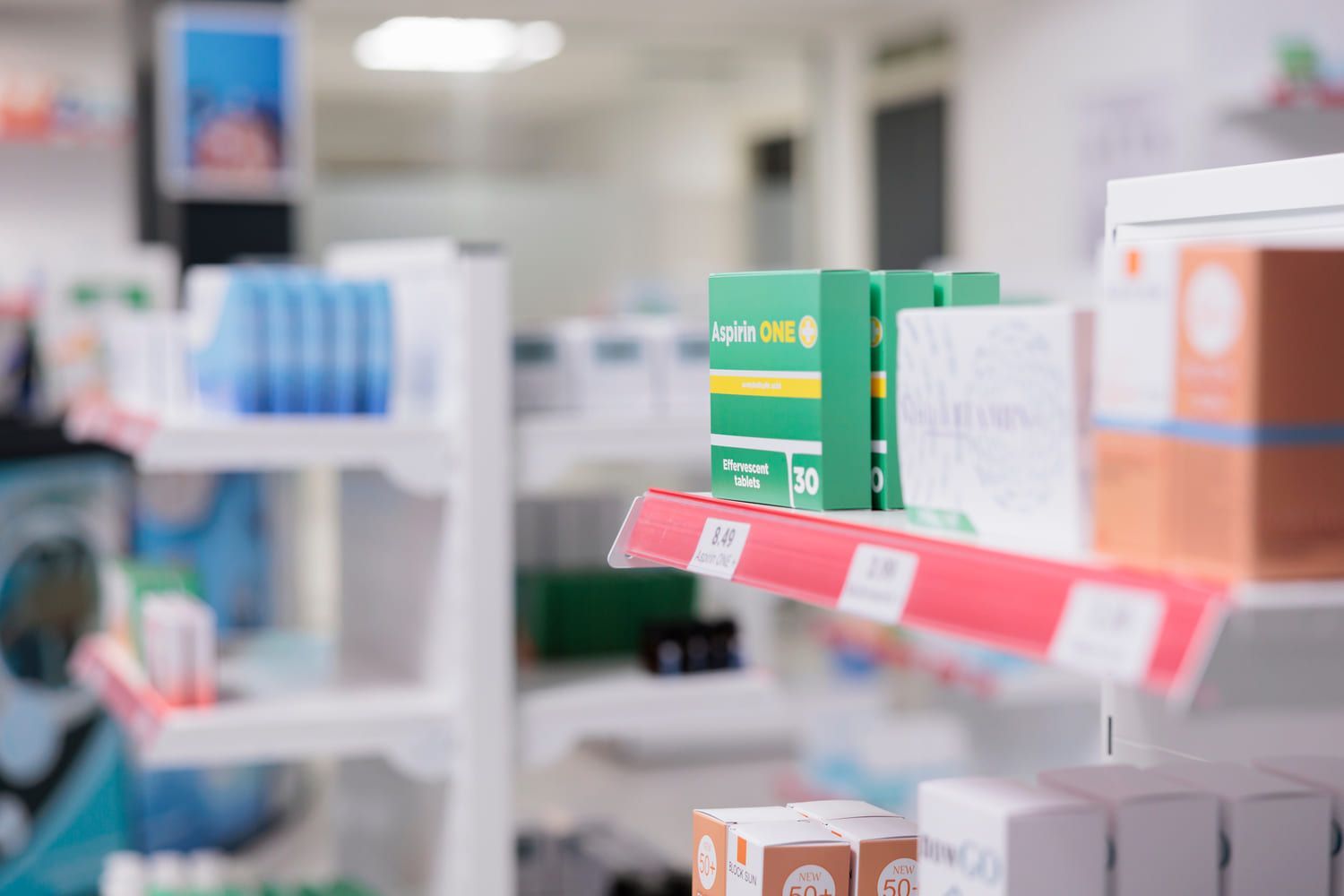 Un estante en una farmacia con cajas de medicamentos en él.