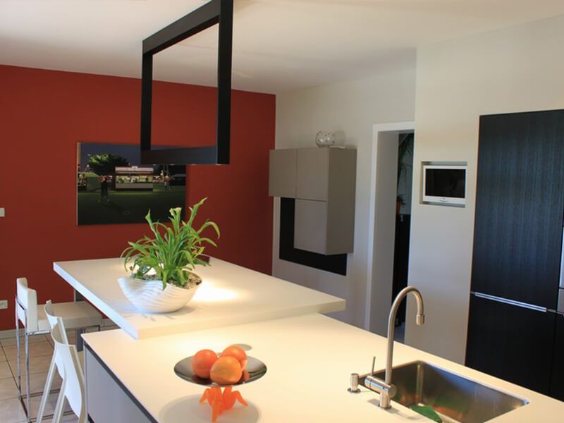 Grande cuisine aménagée avec un mur rouge