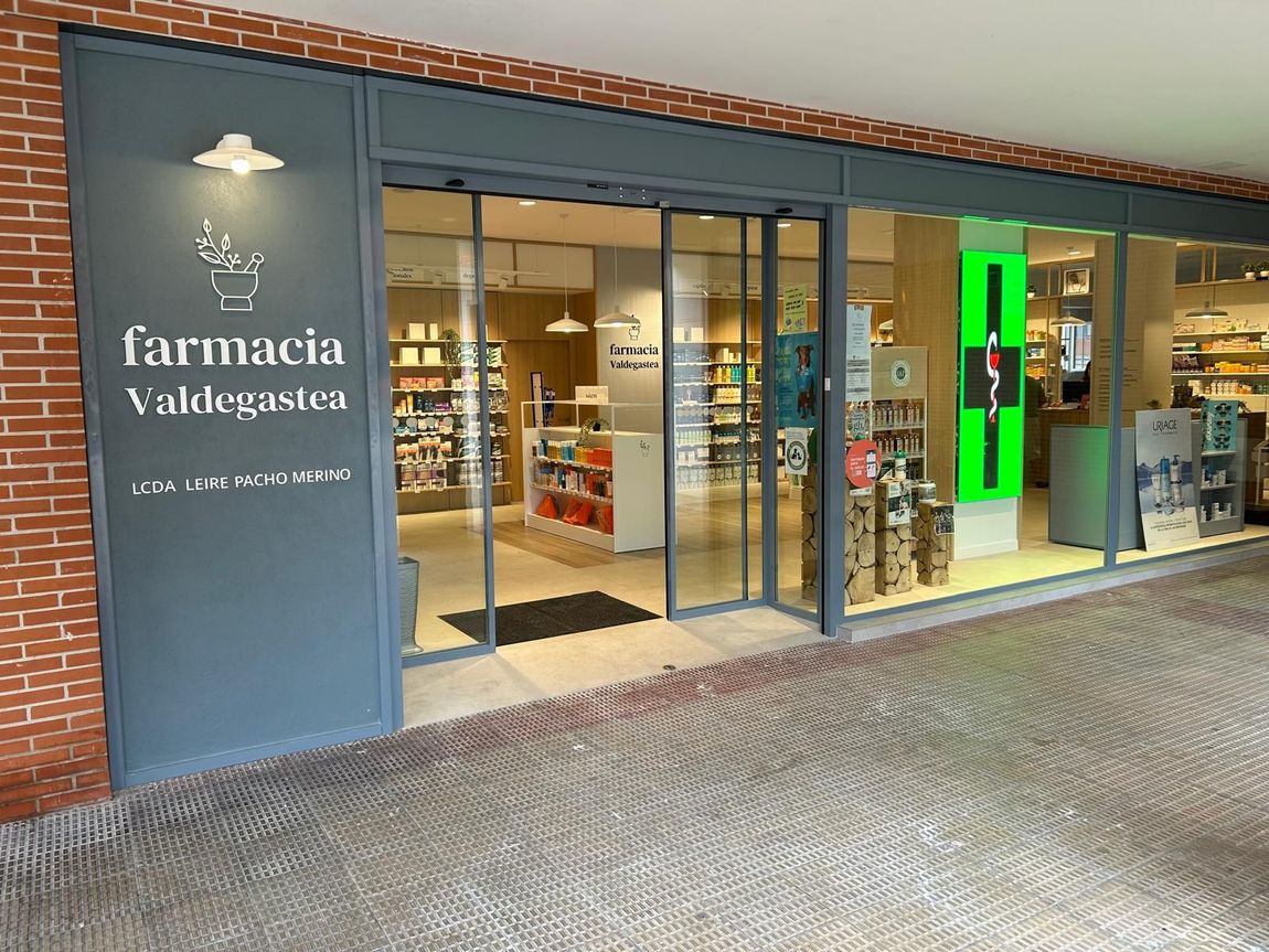El frente de una farmacia con una puerta corrediza de vidrio.