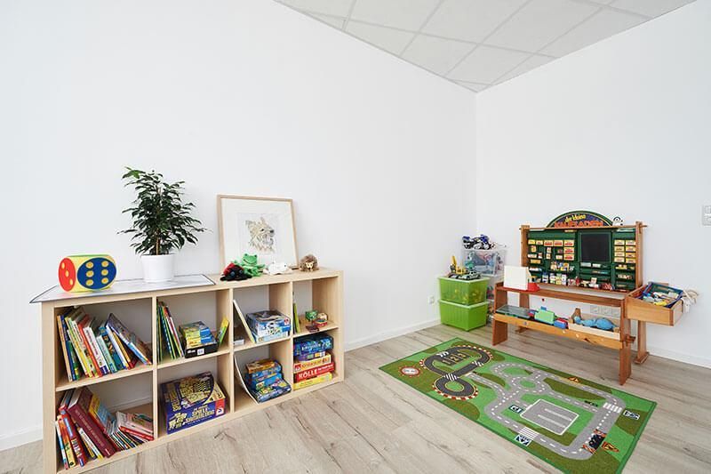 Ein Zimmer mit vielen Spielsachen und Büchern in Regalen