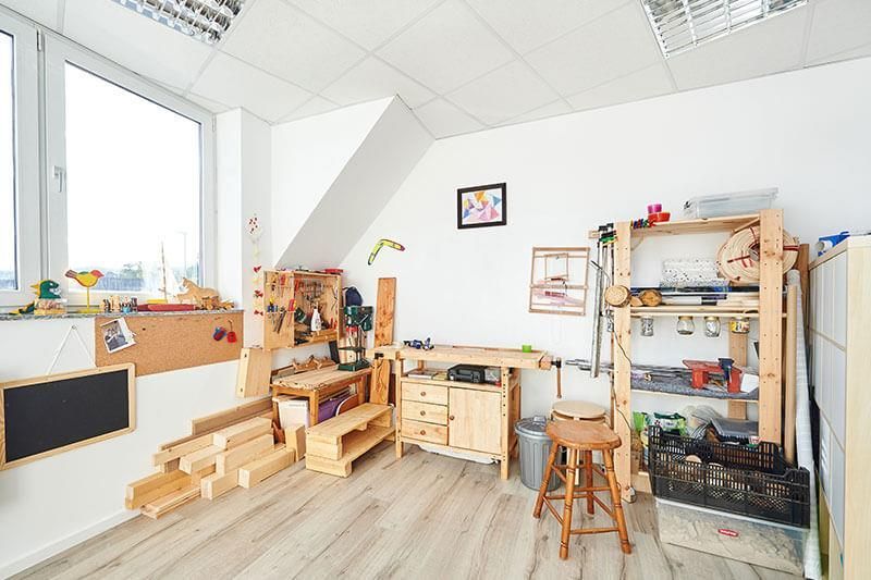 Ein Raum mit einer hölzernen Werkbank und einem Hocker