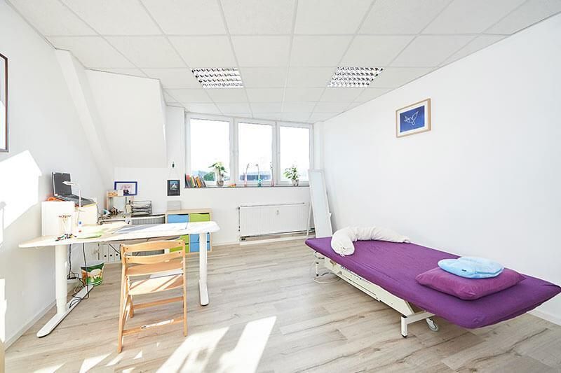 Ein Zimmer mit einem lila Bett und einem Schreibtisch