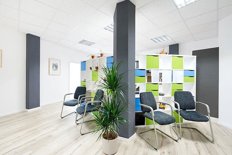 Ein Wartezimmer mit Stühlen und einer Topfpflanze