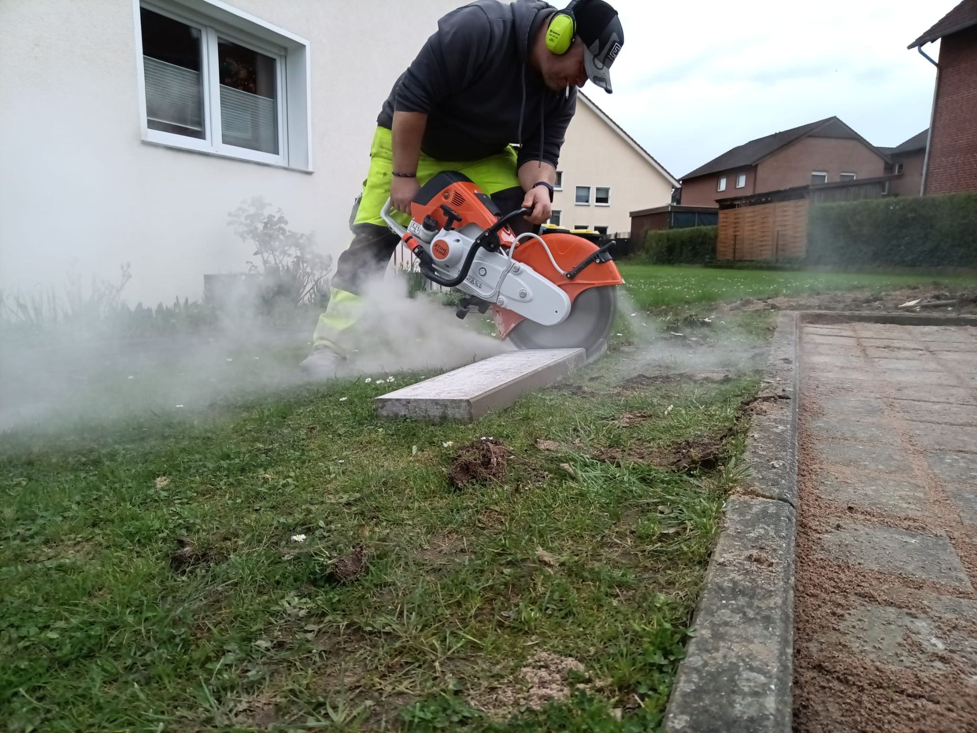 Ein Mann schneidet mit einer Kreissäge ein Stück Beton