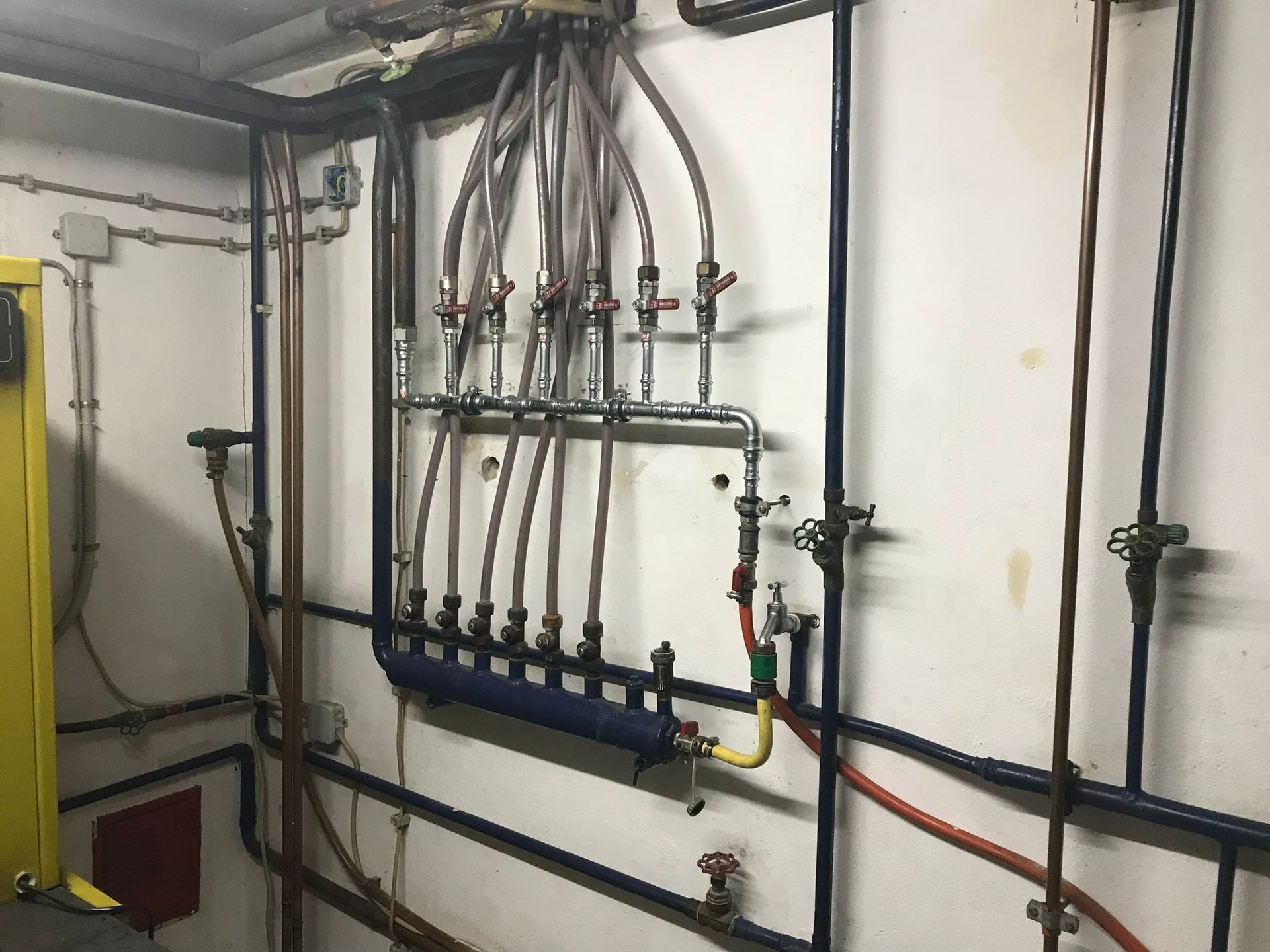 Ein Raum mit vielen Rohren, die an der Wand hängen.
