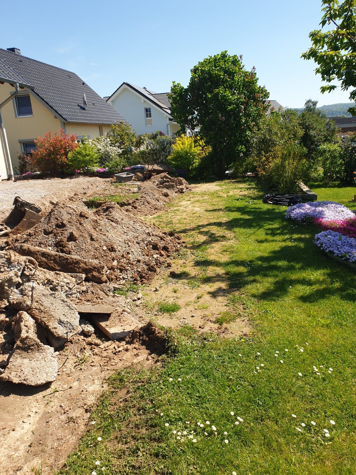 Inmitten eines üppig grünen Hofes liegt ein großer Erdhaufen.