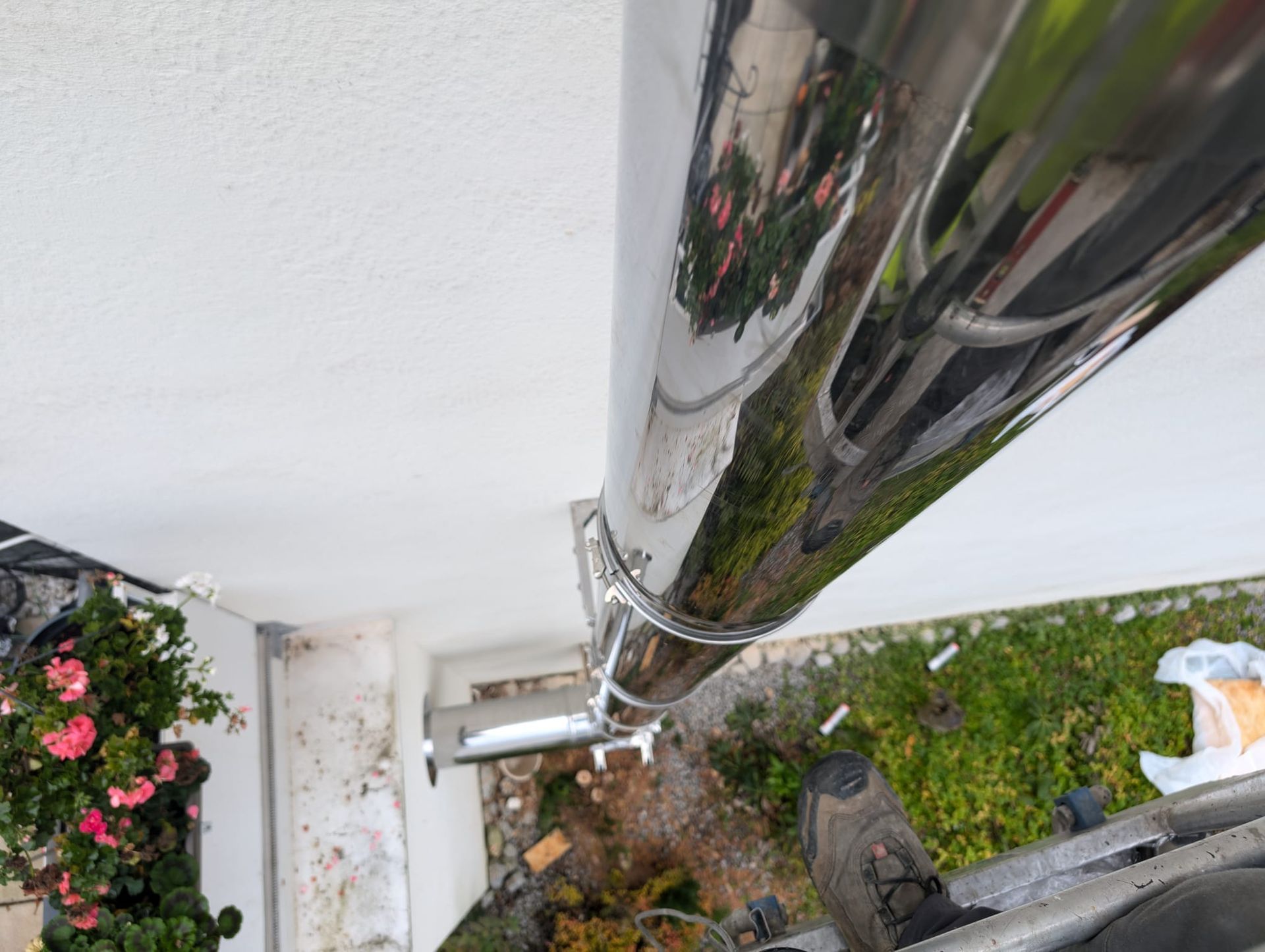 An der Seite eines Gebäudes wird ein Edelstahlrohr angebracht.