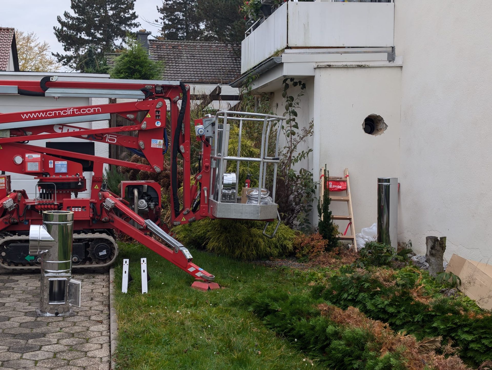 Ein roter Kran steht vor einem weißen Gebäude