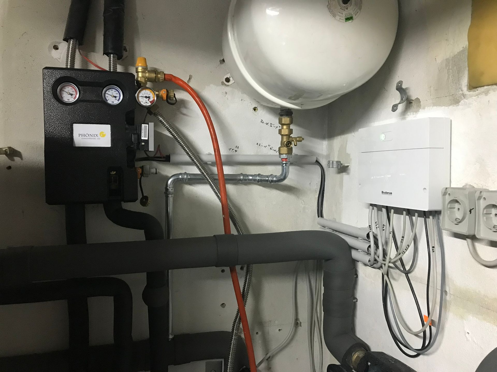 Ein Raum mit vielen Rohren und Kabeln an der Wand.