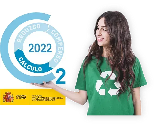 Una mujer con una camisa verde sostiene un cartel que dice 2022