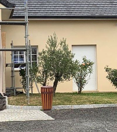 Poubelle en forme de baril devant une maison
