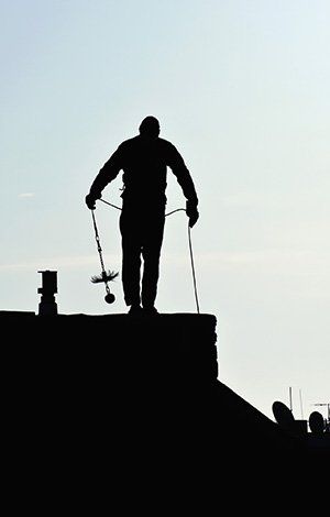 Monsieur en contre-jour qui part en mission ramonage de cheminée
